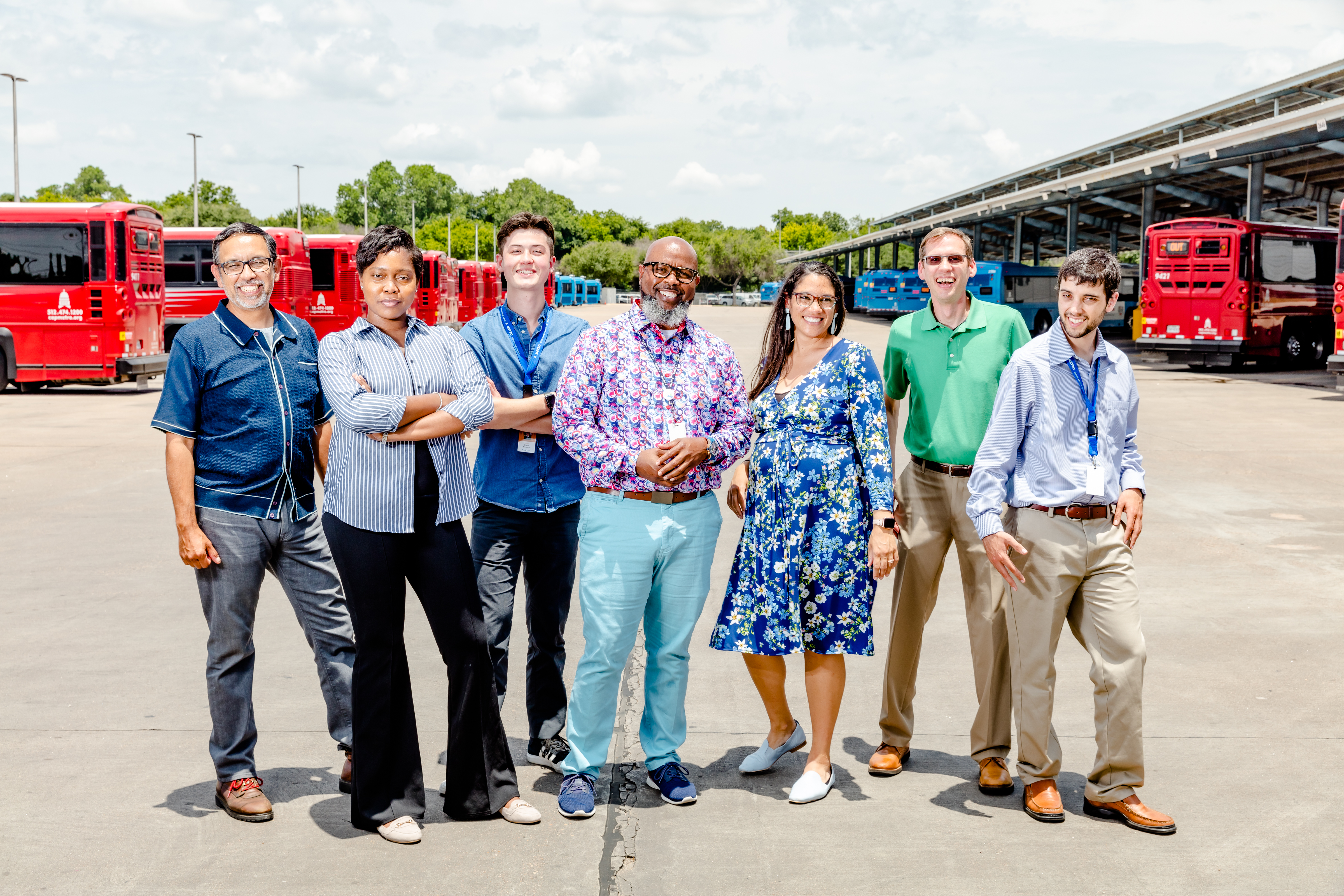 A diverse group of CapitalMetro employees smiling while sitting on a MetroBus