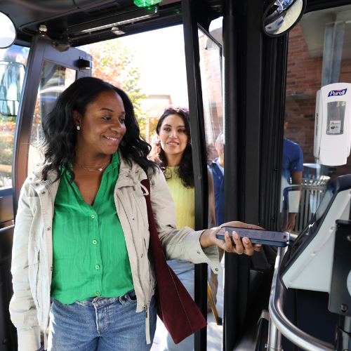 Rider using a mobile device to tap to pay bus fare