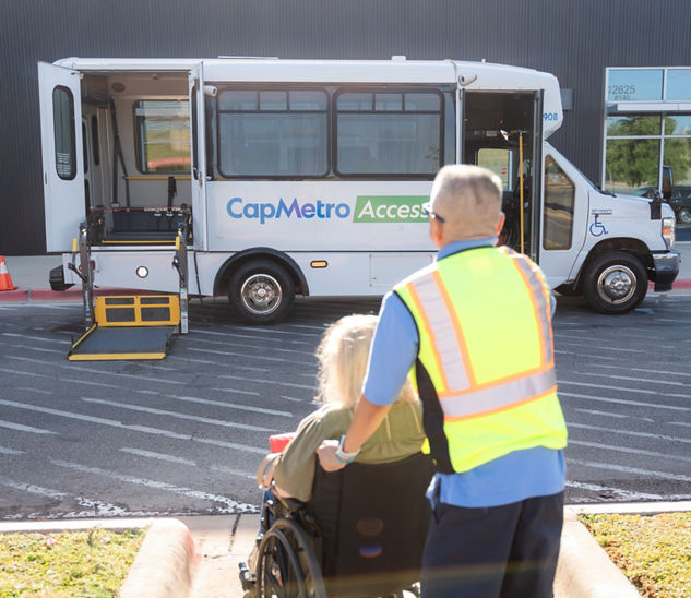 Driver assisting a passenger in a wheelchair onto the vehicle